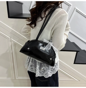 Dettaglio borsa a spalla in PU nero con fiocco in pizzo bianco e targhetta in metallo
