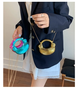 Metallic woven clutch bags in gold, blue and pink shown on model with gold chains
