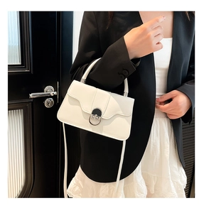 Detailed shot of the white leather shoulder bag featuring a silver semi-circular metal lock