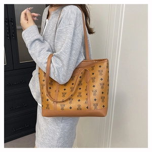 Detail of brown monogram tote bag featuring bear patterns and lychee leather texture