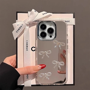 Detailed view of luxury mirror phone case with sparkling rhinestone bows and clear frame