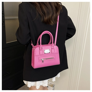 Detail of pink PU leather Boston bag with silver plaque and horizontal front zipper