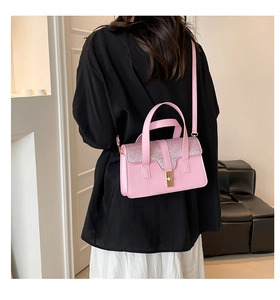 Detail of pink leather handbag with glittery sequined flap and golden metal clasp lock