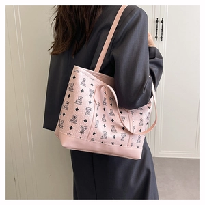 Detailed view of the pink leather tote bag with black bear patterns and long shoulder strap