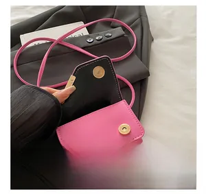 Detailed close-up of pink leather handbag showing gold magnetic buckle and neat stitching