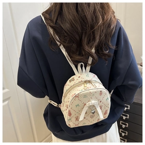 Detailed back view of mini cream backpack with cute prints and bow on a blue sweatshirt