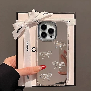 Close-up of mirror phone case with four sparkling rhinestone bows for iPhone 15