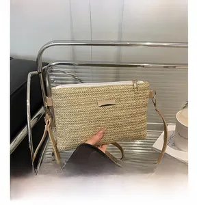 Close-up of woven straw texture with white zipper and gold metal pull on beige bag
