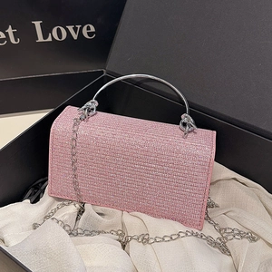 Pink rhinestone evening clutch bag with round metal handle and silver crossbody chain