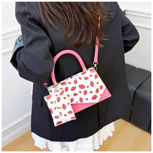 Detail view of pink PU leather shoulder bag with strawberry print and matching card pouch
