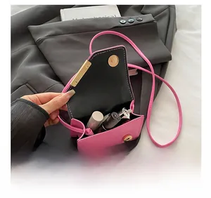 Mini pink crossbody bag detail showing interior capacity for lipsticks and gold hardware