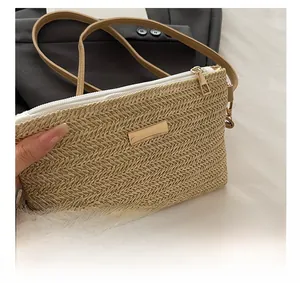 Close-up of hand-woven straw crossbody bag with golden hardware and leather strap