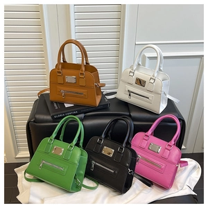Five assorted colors of Boston handbags in leather texture on a minimal display