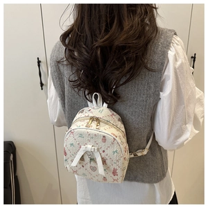 Detailed back view of a white mini backpack with pink rabbit prints and 3D bow accent