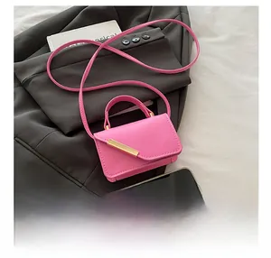Macro detail showing the mini bright pink crossbody bag size compared to a smartphone