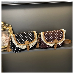Close-up of retro polka dot canvas bags with lace trim and brown synthetic leather straps
