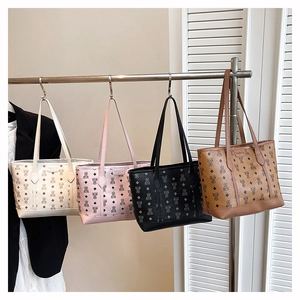 Close-up of four printed tote bags in beige, pink, black, and brown with PU leather texture