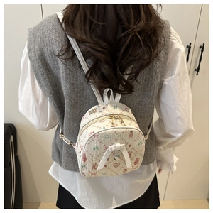 Vue arrière d'un mini sac à dos beige avec motifs d'ours et un nœud décoratif blanc