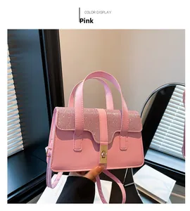 Close-up of pink crossbody bag featuring sparkling rhinestone flap and golden metal clasp