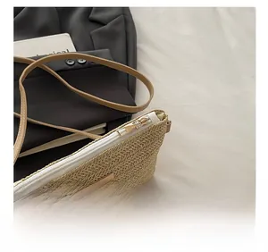 Detail view of smooth golden metal zipper and woven texture on beige shoulder bag