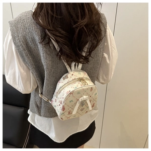 Detailed view of mini cream backpack featuring colorful bear prints and a 3D bow accent