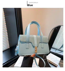 Detail view of light blue handbag with shimmering rhinestone flap and golden twist lock