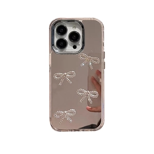 Silver mirror iPhone case with sparkling rhinestone bows on a sleek reflective surface
