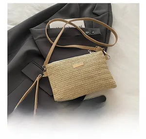 Detail showing the straw crossbody bag texture with gold plate and removable straps