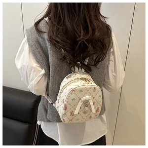 Vue détaillée du dos d'un mini sac à dos crème avec motifs d'ours, fleurs et nœud blanc