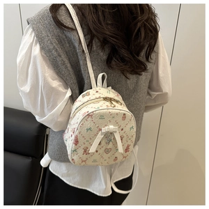 Détail du mini sac à dos avec imprimé d'ours fleuri et un nœud blanc en relief