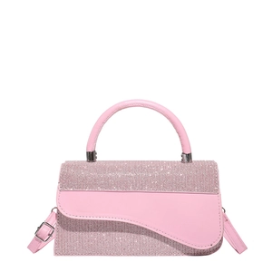 Pink rhinestone handbag with asymmetric flap and adjustable strap on white background