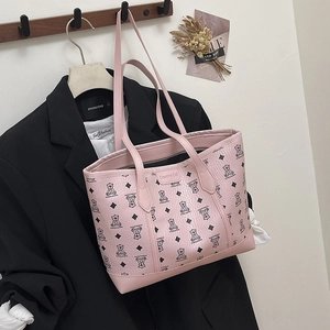 Pink tote bag with cartoon bear patterns and long straps shown on a black suit jacket