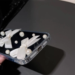 Elegante transparante iPhone-hoes met witte satijnen strikken en parels op zwarte basis