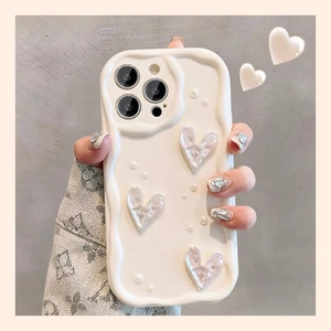 Detail of cream wavy iPhone case featuring metallic silver hearts and pearl accents