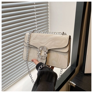 Detail of marble pattern shoulder bag with sparkling crystal buckle and silver chain strap