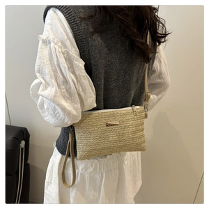 Detail of oat straw woven shoulder bag with adjustable strap shown on model side profile