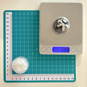 Close-up of a round phone socket with white bowknot detail on a mini storage box