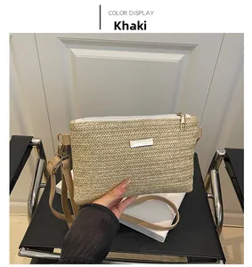 Close-up of woven straw shoulder bag in khaki with adjustable strap and metal logo plate