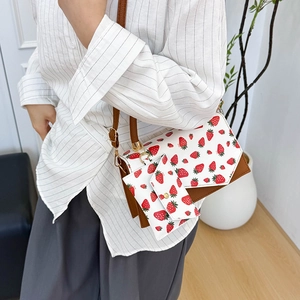 Crossbody bag with strawberry print, brown leather trim, and matching mini coin purse