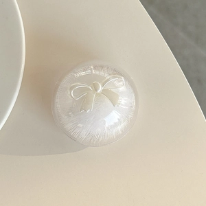 Detail of round phone grip featuring white mink fur and an elegant bow relief ornament