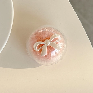 Detail of pink faux fur phone grip with a white pearl bow under a clear round cover