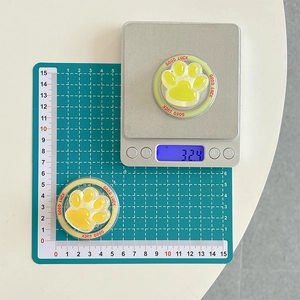 Vue macro montrant le diamètre de 5cm et le poids de 32g du support patte de chat