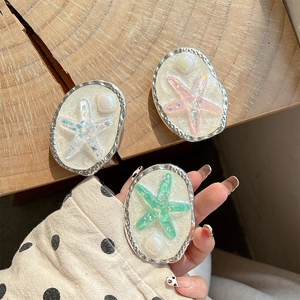 Detail of glitter starfish phone grip with vintage silver frame in pink and green
