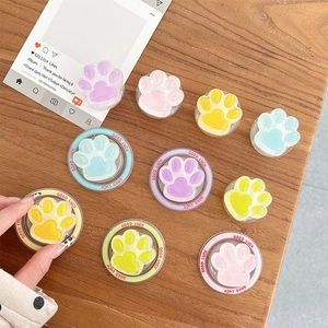 Support de téléphone patte de chat coloré aux tons pastel sur bureau en bois