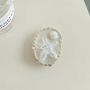 Close-up of starfish phone grip with silver textured frame and pearlescent white base