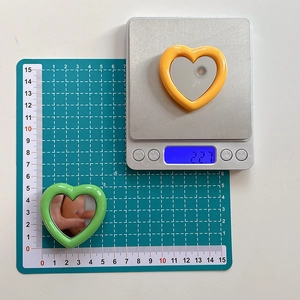 Collapsible heart-shaped mirror phone socket stand in green and orange variants