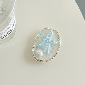 Detailed view of silver oval starfish phone socket with sparkling blue sequins and glitter