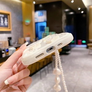 Close-up of white wavy edge phone case with pearl strap and precise bottom cutouts