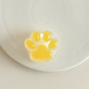 Macro de support téléphone patte de chat jaune 3D avec finition résine sur assiette blanche
