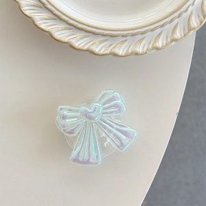 Close-up of iridescent bow phone socket with heart detail and pearly finish